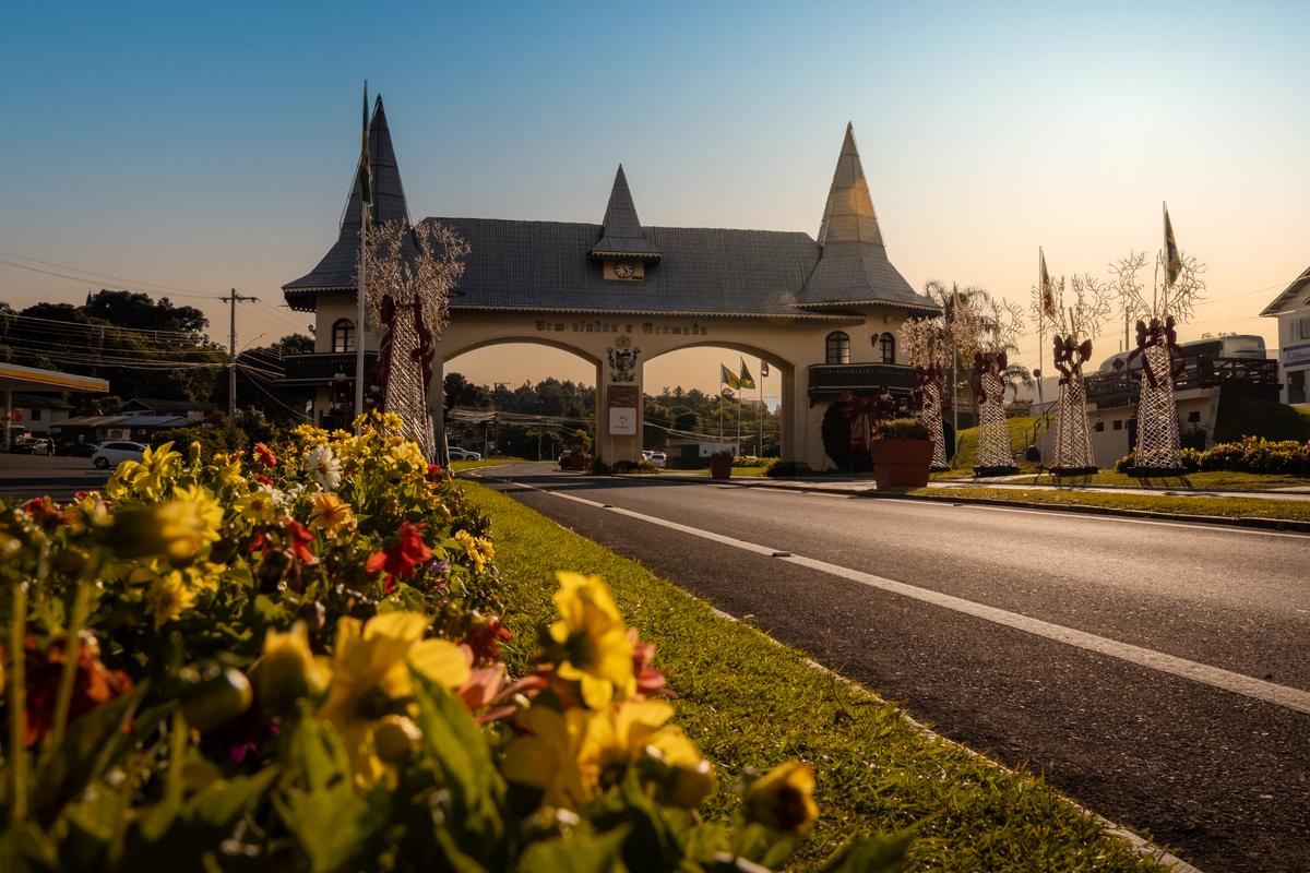 "Grupo de pessoas participando de uma visita técnica avaliando um imóvel luxuoso em Gramado, com ênfase na estrutura e design externo."